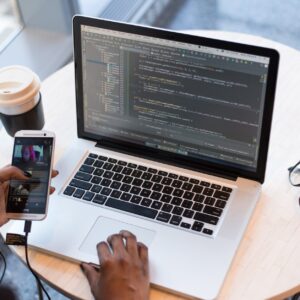 person hold gold htc android smartphone in front of macbook pro